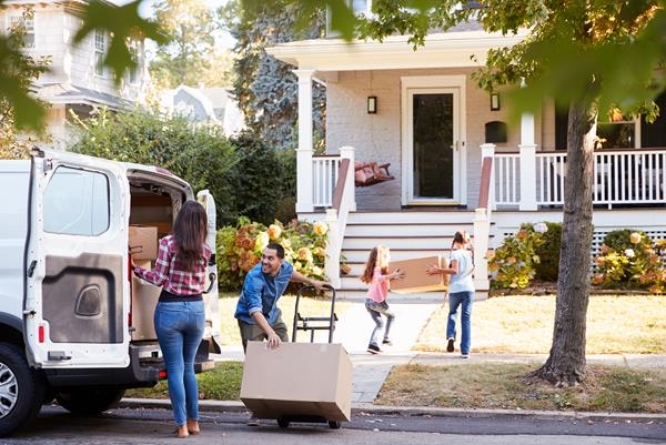 Family unloading van moving boxes