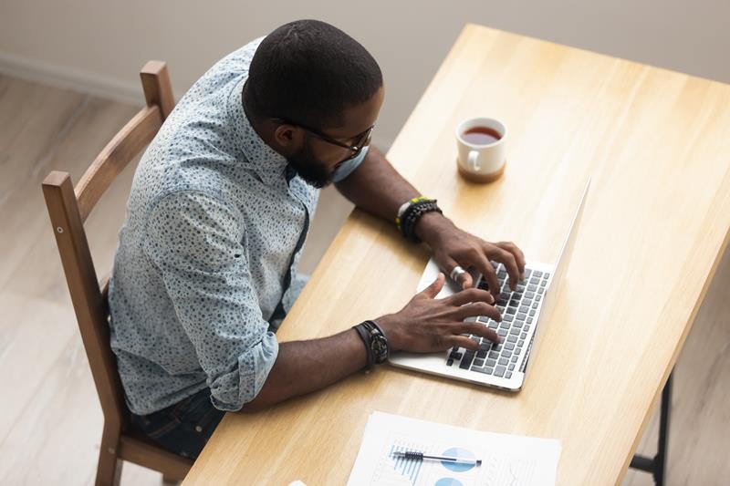 African American male Realtor typing on laptop 