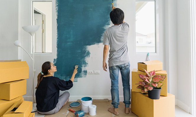 couple-painting-wall-teal-moving-boxes