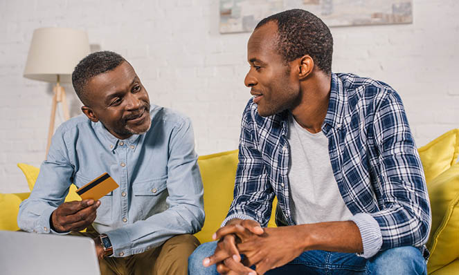 02-two-american-males-talking-credit-card-laptop