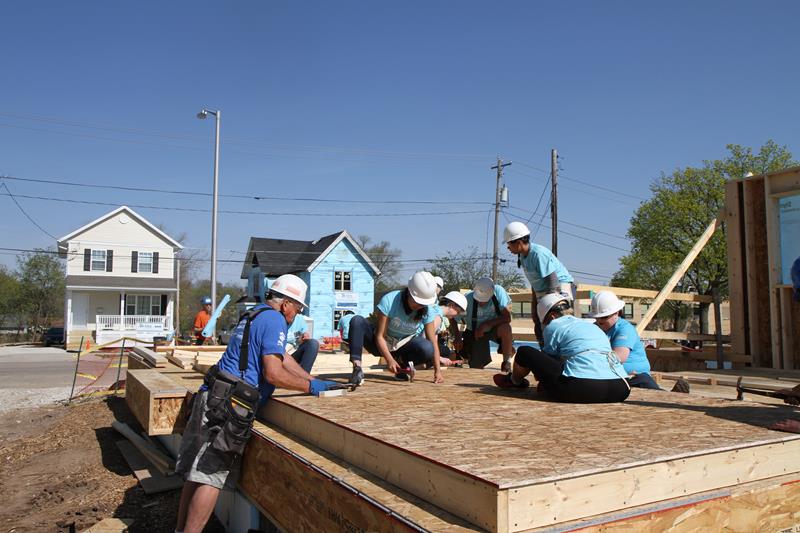 Waterstone Mortgage employees hammer nails into foundation of new home with guidance from Habitat for Humanity project team