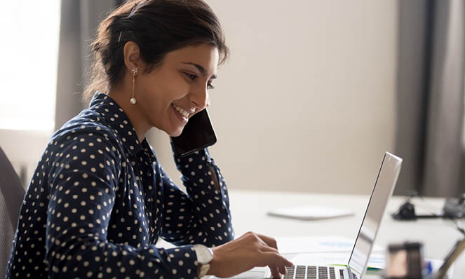 woman-polka-dot-shirt-smiling-at-laptop-drop-earings