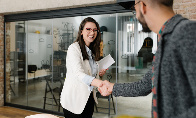 woman-white-blazer-button-shirt-shaking-mans-hand-business-office-glass-windows