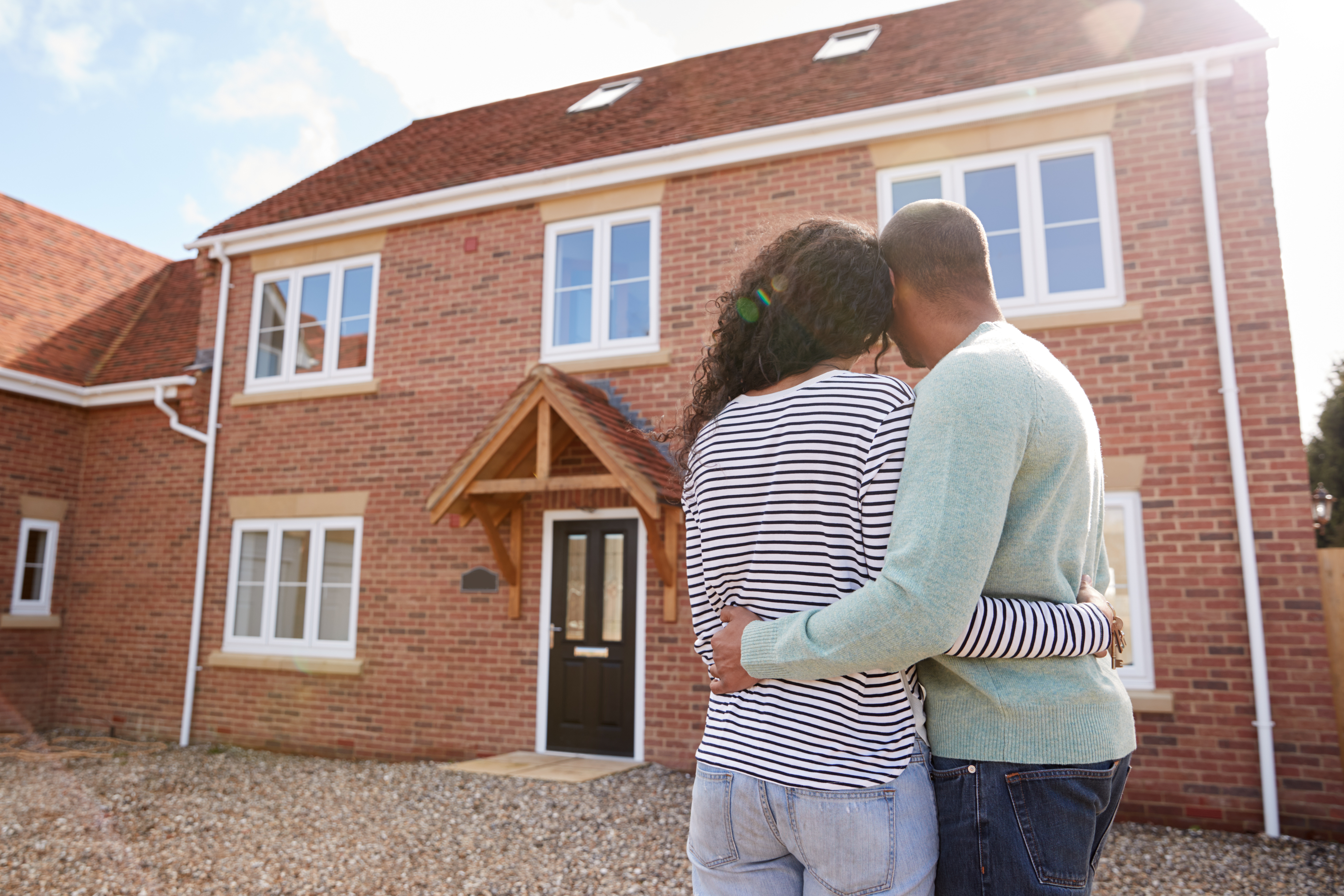 couple-looking-at-brick-house-new-construction