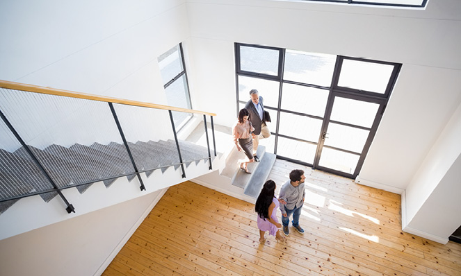 couple-looking-through-open-concept-home-with-realtor