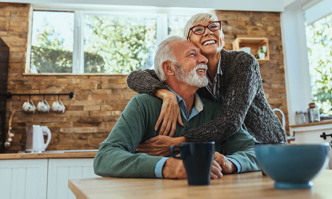 older-couple-sitting-at-home-happy-coffee-cup