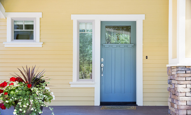 yellow-house-light-blue-front-door-wood-coloumn-planter-with-flowers