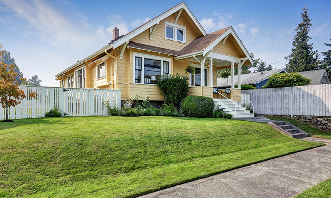 yellow-house-white-fence-green-grass