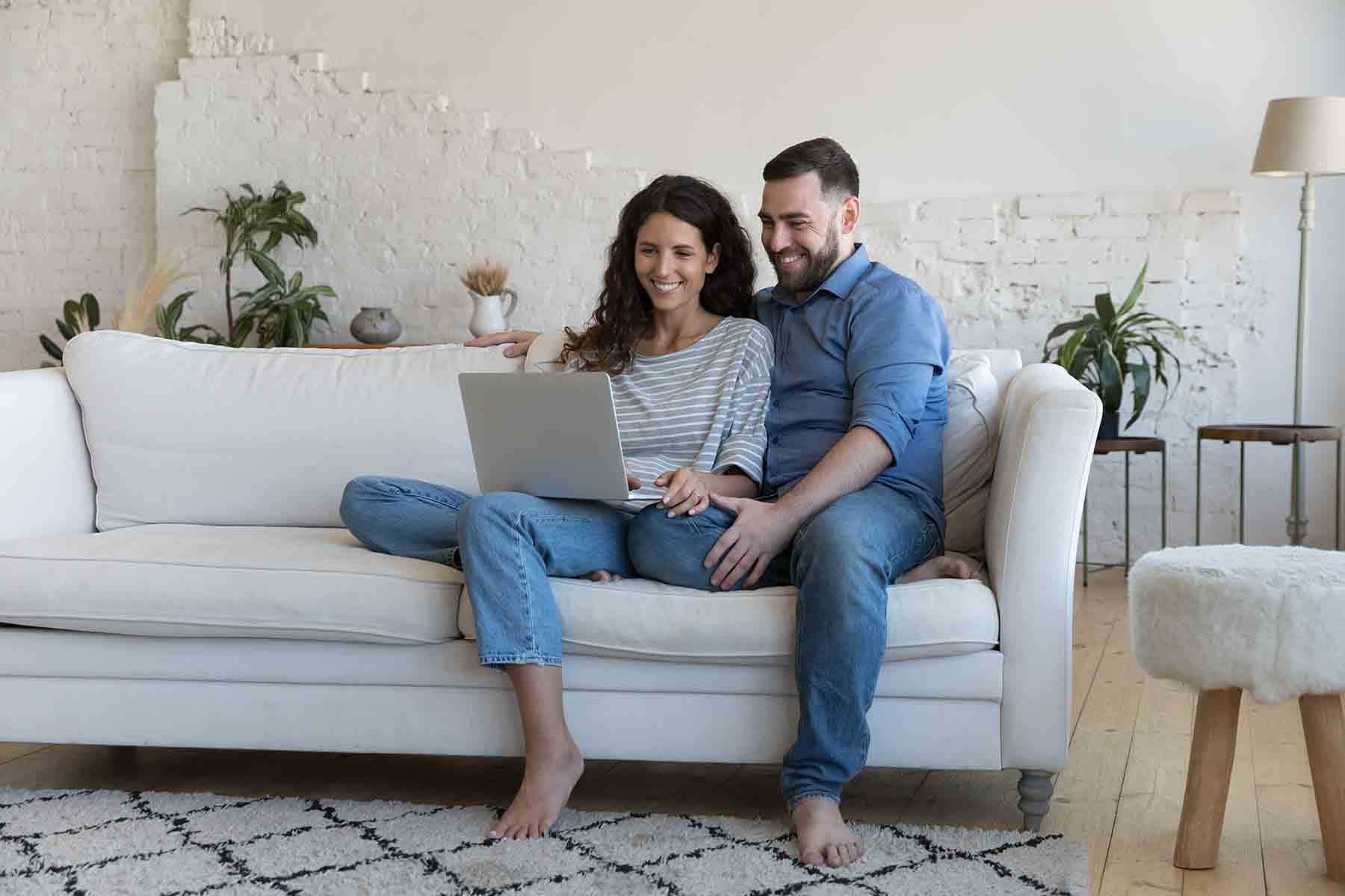 A young couple searches online for ways to make homebuying more affordable