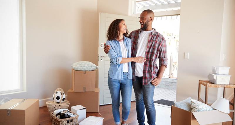 young-couple-walking-into-new-home-with-boxes