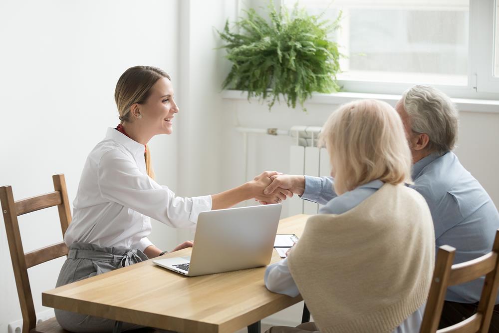 elderly-couple-consultation-young-woman-office-hand-shake